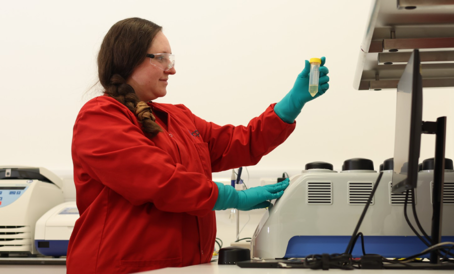A woman in red holding a tube